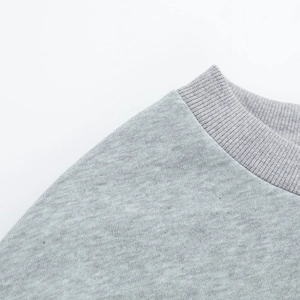 Gros plan du col rond côtelé et de la texture en coton doux d'un sweat-shirt gris clair