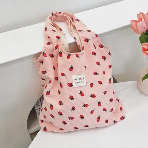 Détail du sac fourre-tout en velours côtelé rose avec imprimé fraise et étiquette