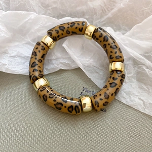 Detail of leopard print resin links with gold metal spacers on this acrylic bangle bracelet