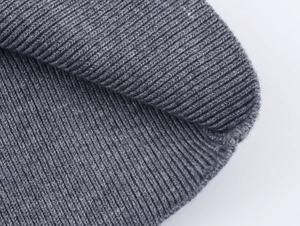 Gros plan d'un bonnet gris en maille côtelée montrant la texture et le tissage épais