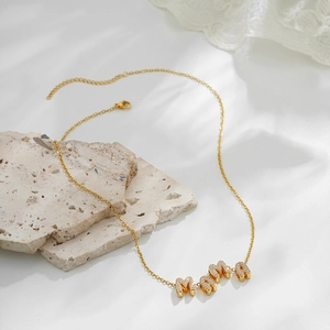 Close-up of a 18k gold necklace featuring a zircon-studded MAMA letter pendant