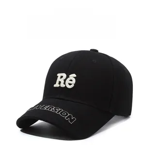Detailed close-up of white 3D embroidery and durable cotton twill on a black baseball cap