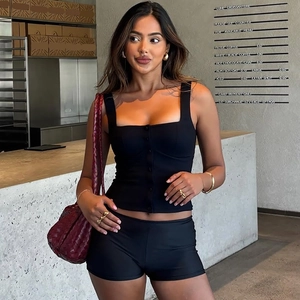 Detail of a slim fit black camisole paired with a burgundy woven shoulder bag in a cafe