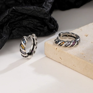 Macro shot of silver twisted hoop earrings with rainbow cubic zirconia and vintage texture