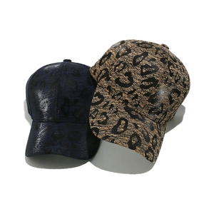 Navy blue and khaki leopard print baseball caps with a slight leather shine finish