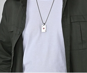 Detail of Ace of Hearts poker pendant on a silver chain worn with a layered casual outfit
