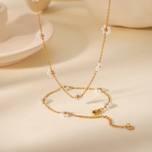Dettaglio della collana in acciaio inossidabile dorato e bracciale con perle a margherita