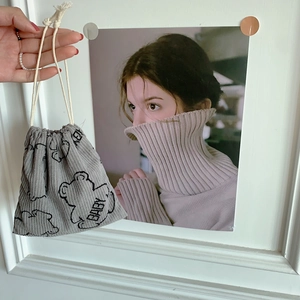 Detailed texture of grey corduroy drawstring pouch with cute baby bear embroidery