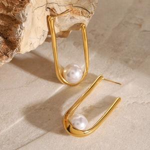 Polished 18k gold plated U-shaped pearl earrings on a natural stone background