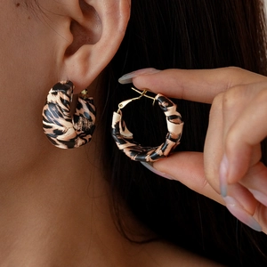 Close-up of leopard print hoop earrings with gold clasp showing size and detail