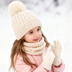 Close-up of kids winter knit set featuring pompom beanie, scarf, and touch gloves