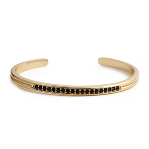 Minimalist gold-plated open cuff bracelet featuring a row of inlaid black cubic zirconia