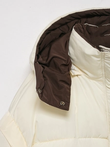 Detail of the high collar with hidden zipper and metal snap buttons on a padded coat