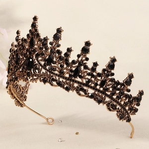 Detailed close-up of golden crown with intricate black crystals and floral engravings