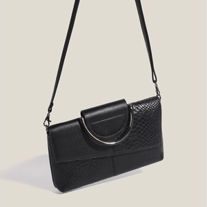 Elegant black leather handbag with snakeskin texture, metal handle and detachable shoulder strap