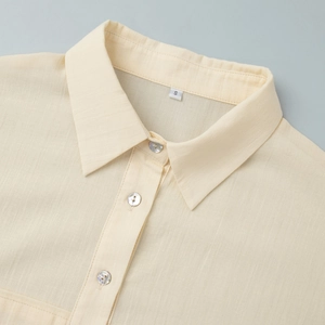 Detail of cream linen shirt featuring vertical texture and mother-of-pearl buttons