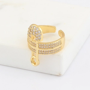 Close-up of golden safety pin ring with micro-pave zircons and adjustable open band