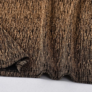 Gros plan du tissu métallique doré avec rayures verticales et texture en maille brillante