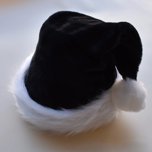 Detail of plush black and white Christmas hat with soft faux fur trim and pom-pom