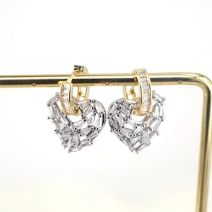 Close-up of gold-plated heart earrings with sparkling cubic zirconia on a display stand