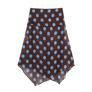 Detailed view of brown chiffon skirt with light blue polka dots and asymmetrical hemline