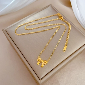 Macro detail of gold bow necklace showing adjustable extension chain and S925 hallmarked tag