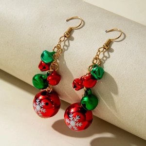 Detail of Christmas earrings featuring red and green bells with white snowflake patterns