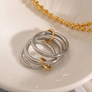 Three linked silver rings with gold connectors on a white ceramic dish for a luxury look