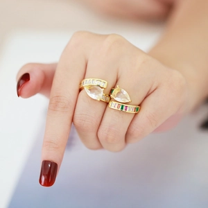 Macro detail of gold adjustable rings featuring a pear-cut stone and colorful zircon accents