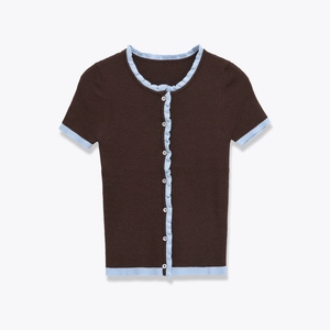 Detail of slim fit knit top with contrast ruffle trim and vertical ribbed texture
