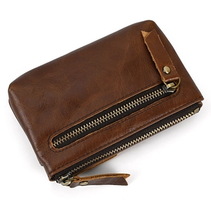 Close-up of vintage dark brown leather coin purse showing zipper pocket and metal rivets