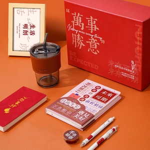 Artistic stationery gift set with red notebooks, glass cup, and pens in a premium box