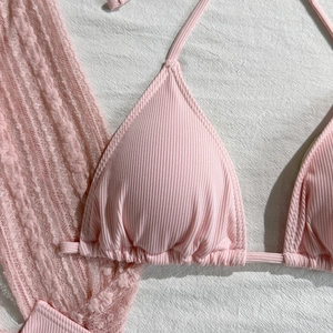 Detail of pink ribbed bikini top with intricate lace knit patterns on soft fabric