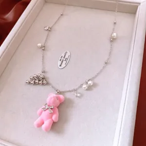 Pink flocked bear pendant necklace with elegant pearls and tassels on jewelry tray
