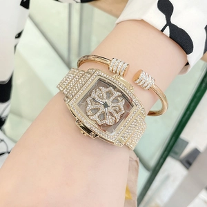 Gold barrel-shaped rotating dial watch set with sparkling crystals and matching bracelet