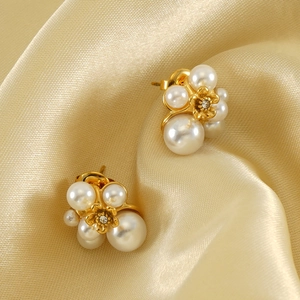 Gold floral pearl cluster earrings with crystals on champagne satin background