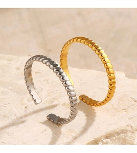 Detailed view of intertwined gold and silver twisted rope rings on a stone surface