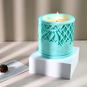 Portavelas verde menta con relieve de bambú y llama parpadeante bajo una suave luz natural
