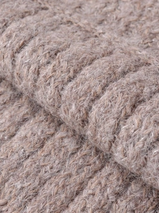 Macro detail of thick light brown knit fabric showing rich texture and wool fiber finish