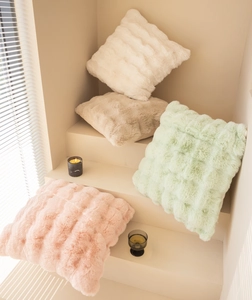Detail of plush faux rabbit fur pillow with soft 3D textured patterns in Morandi colors