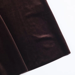Detail shot of luxurious deep brown velvet fabric with smooth metallic silk texture