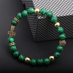 Detail of turquoise beaded bracelet with gold cross pendant and black pavé crystals