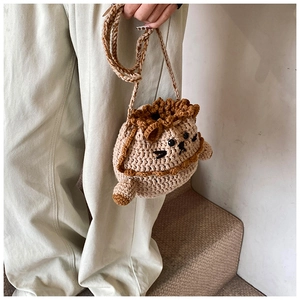 Detailed knit texture of a handmade lion crochet drawstring bag with 3D lion head features