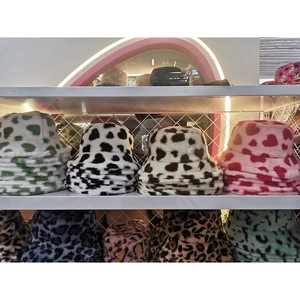 Close-up of fuzzy bucket hats featuring cow prints, hearts and leopard patterns
