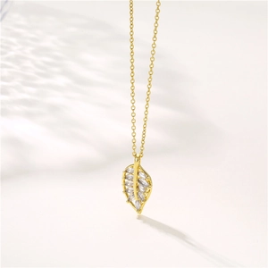 Elegant gold leaf pendant necklace with shimmering zircon crystals on a delicate chain