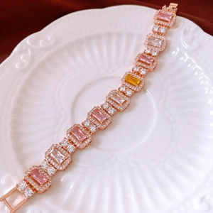 Detail of rose gold bracelet with multicolored square-cut zircons on ceramic plate