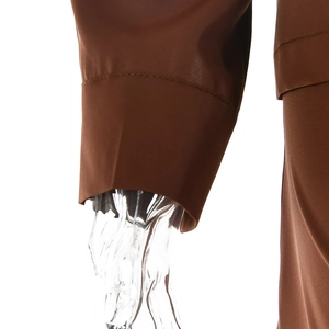 Detail of dark brown shirt cuff with smooth texture on a white background view