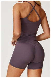 Back view of deep purple yoga set showing criss-cross straps and high-waist shorts