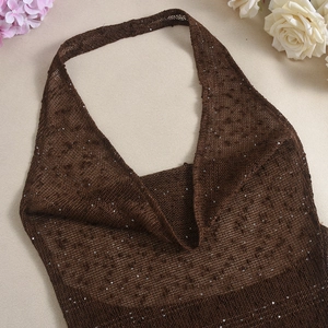 Detailed flat lay of dark brown sequined halter top on textured beige background