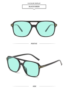 Detail of classic black square sunglasses with green lenses and gold T-metal hinges